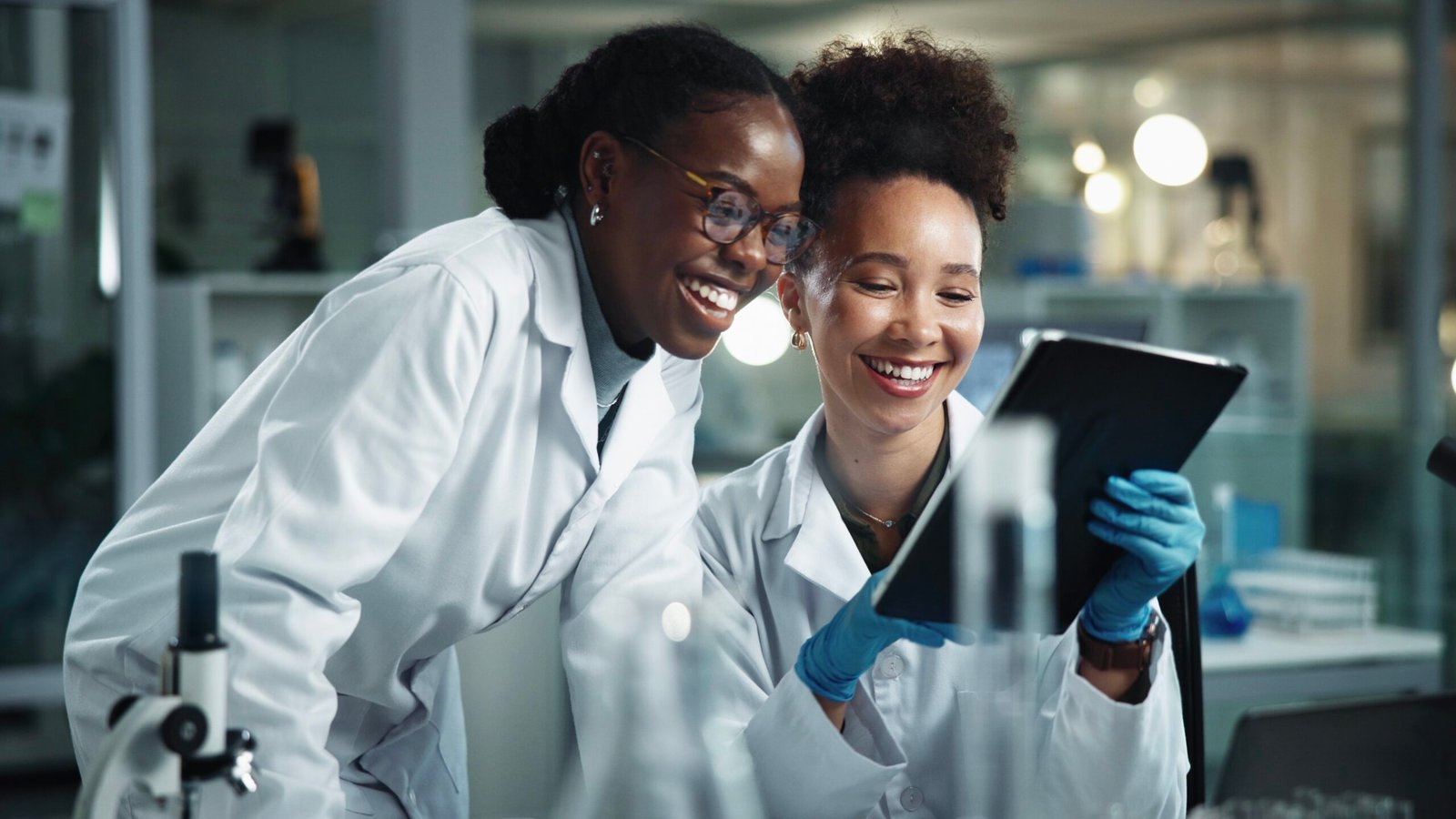 Women, scientist and tablet with research, laboratory and digital study for healthcare science. Happy, technology and bacteria testing for vaccine, drug trail and reading medical report in clinic